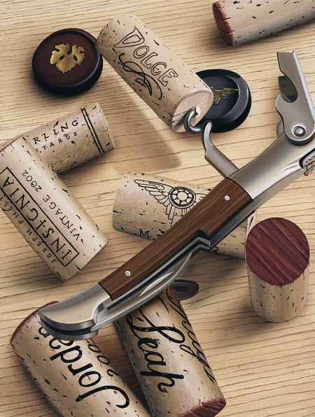 Several wine corks, one still attached to the cork screw.