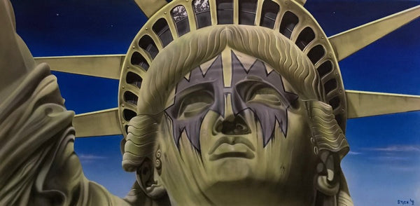 A close up is pictured of the statue of liberty, showing her face, crown, and part of her arm. It is a beige colored statue with a blue gradient featuring stars and clouds in the background. Around her eyes is the smeared, spiked, grey-blue face paint notoriously worn by Ace Frehley of Kiss.