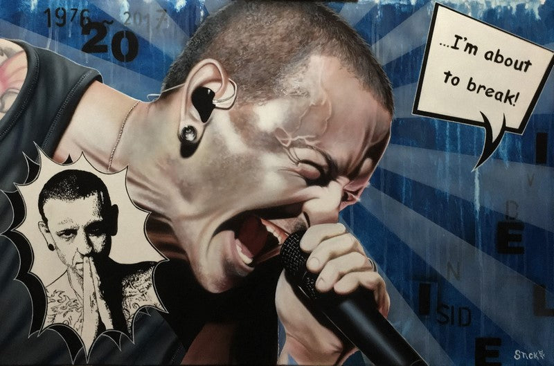 Chester Bennnington of Linkin Park is shown yelling into a microphone. His head is shaved and he is wearing a black tank top. In the left bottom corner is a small sketch of Chester, facing forwards with his hands together. On the upper right side is a square text bubble saying "...I'm about to break!" Various letters and numbers are in black against a light and dark blue striped background.