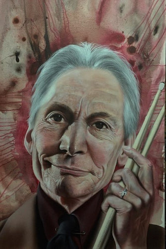 Charlie Watts from Rolling Stones is shown from the chest up in a maroon suit smiling slightly, with a pair of drumsticks in his raised hand. The background shows splashes of reds and black in a water-color moving outwards from his face.